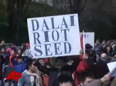 人们举起标语,抗议达赖(西雅图电视台视频截图).jpg