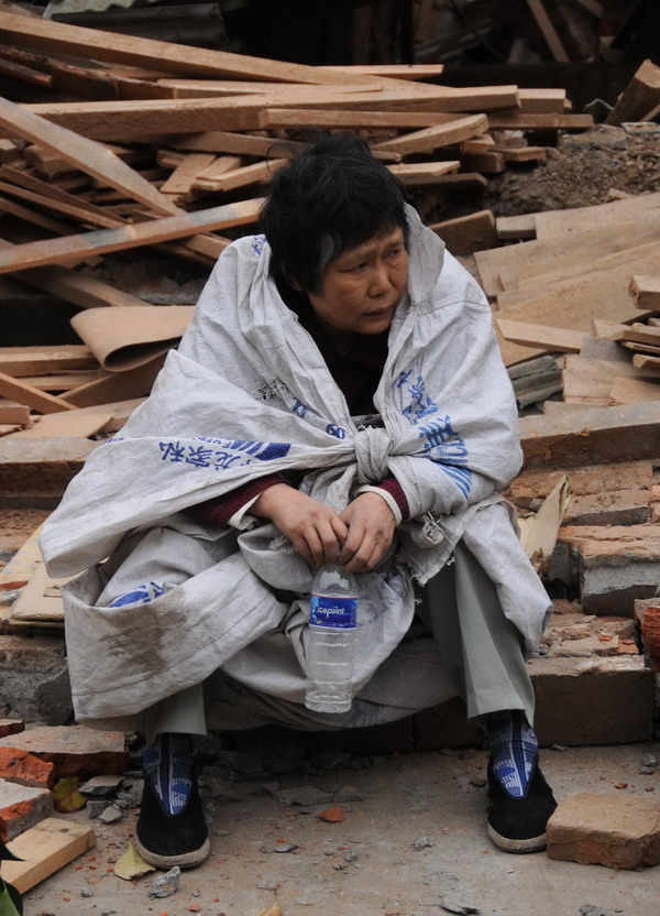 An old woman waits to rescue, she has only an empty water bottle