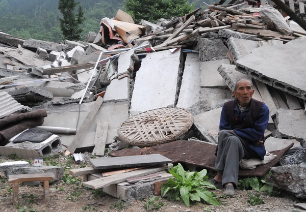 In the Beichuan county, an old man sits nearby his home
