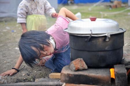 10岁的王永霞在北川县地震灾区临时安置点内生火做饭.jpg