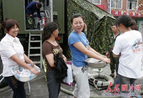 5月25日，四川彭州小渔洞镇的村民在等待进入野营淋浴车沐浴.jpg