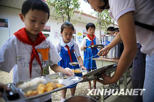 6月23日，在都江堰市过渡校点“皖川学校”，北街小学的学生排队领取午饭