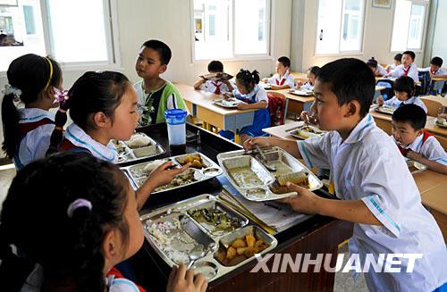 月23日，在都江堰市过渡校点“皖川学校”，学生干部在检查一名同学（前右一）的餐盘，提醒同学爱惜粮食 ...