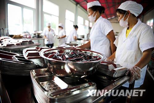 月23日，在都江堰市过渡校点“皖川学校”，食堂的工作人员在准备餐具