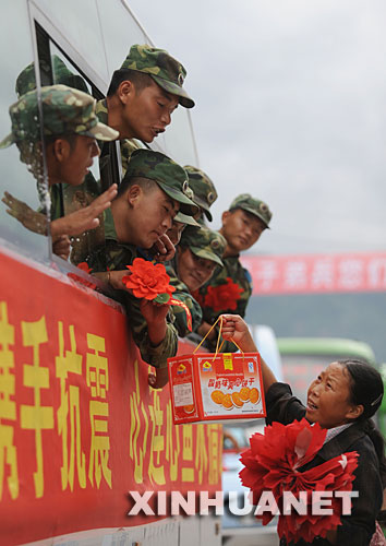 7月21日，四川省什邡市蓥华镇一位妇女给撤离的解放军官兵送来食品