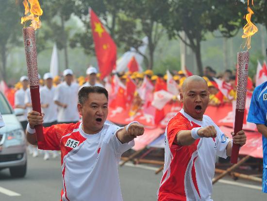 火炬手逯军（右）与火炬手梁少宗交接后庆祝