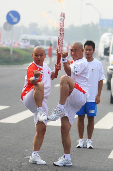 火炬手释延鲁（前右）与下一棒火炬手逯军交接后合影