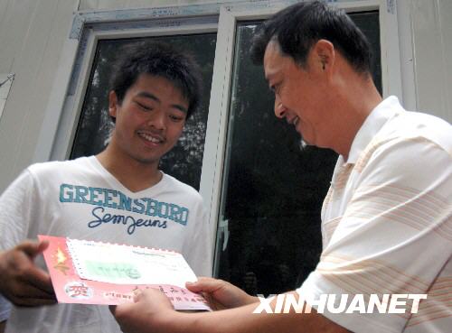 7月27日，易爽（左）从中国民航飞行学院党委书记朱勇手中接过录取通知书