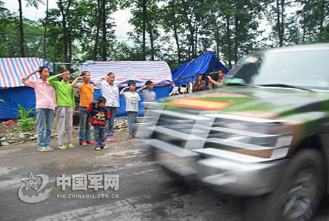北川县陈家坝乡的孩子们自发地向来往的救灾军车敬礼