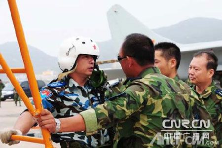 航空兵某师副师长严锋在飞行前与机务人员进行交接。