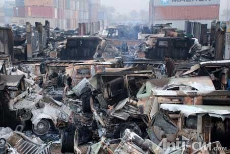 12月7日，在巴基斯坦靠近阿富汗的边境城市白沙瓦郊区，一名男子站在被烧毁的军用车辆残骸旁。 ...