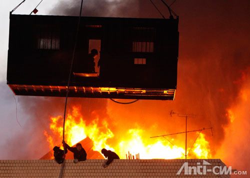 1月20日，首尔，警察在货柜箱的保护下接近被困在楼顶的动迁户。