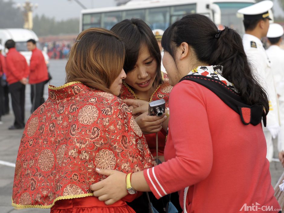 参会人员在天安门广场拍照留念后观看照片.jpg