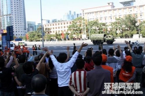 刚刚参加完阅兵的受阅部队驶过北京市区时向首都人民致意