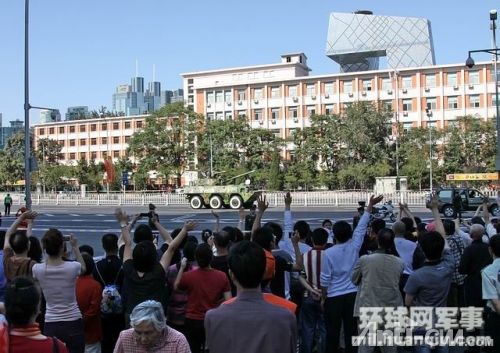 刚刚参加完阅兵的受阅部队驶过北京市区时向首都人民致意