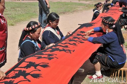 佤族妇女在60米织布长卷上一针一线刺绣图案.jpg